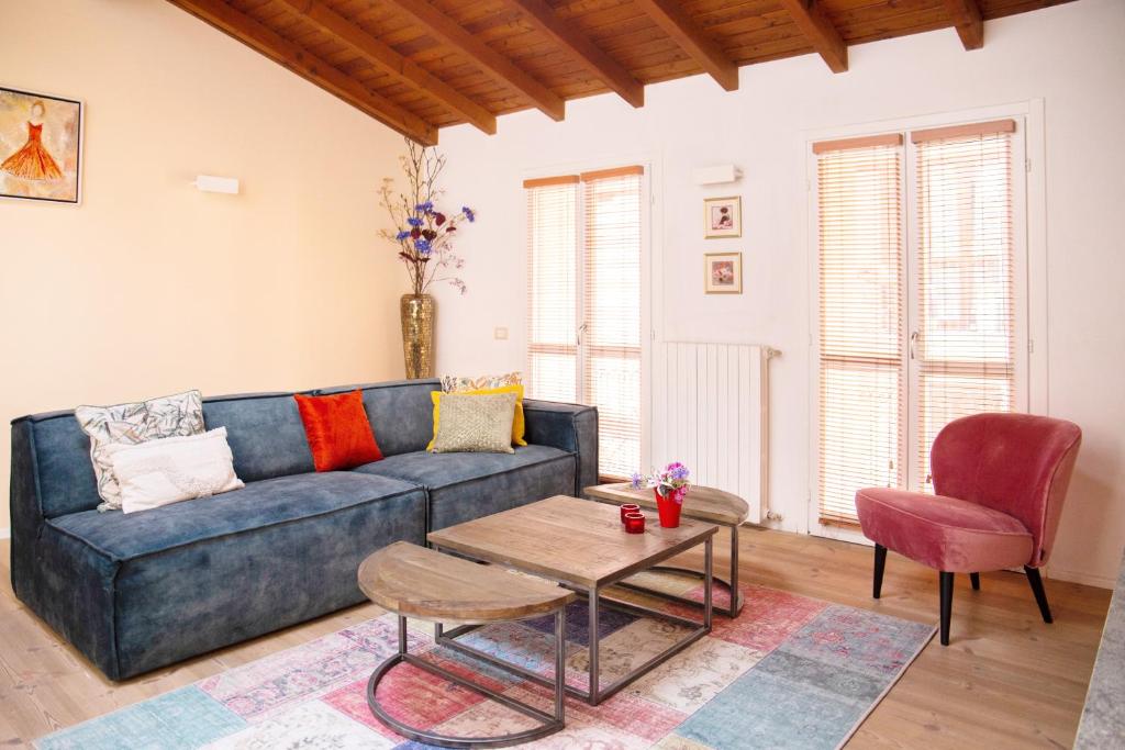 ein Wohnzimmer mit einem blauen Sofa und einem Tisch in der Unterkunft La Sorpresa - luxury apartment in historic city center in Arona