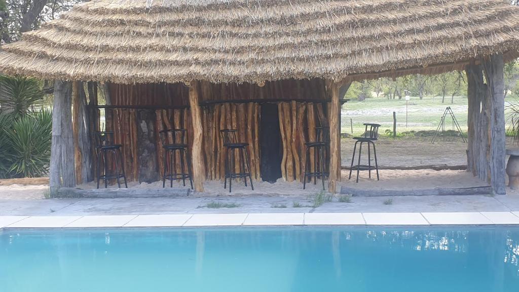 una cabaña con sillas y una piscina en Paradise Camp Game Lodge, en Groutfontein