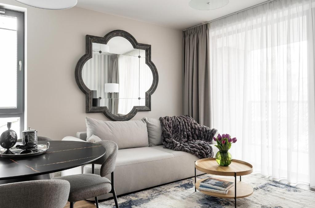- un salon avec un canapé blanc et un miroir dans l'établissement Lion Apartments - SCALA City Center Apartments&Parking H, à Gdańsk