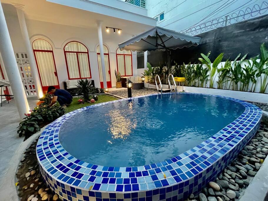 een zwembad met blauwe tegels rond een huis bij Holi Dolce Vita Pool Villa in Nha Trang
