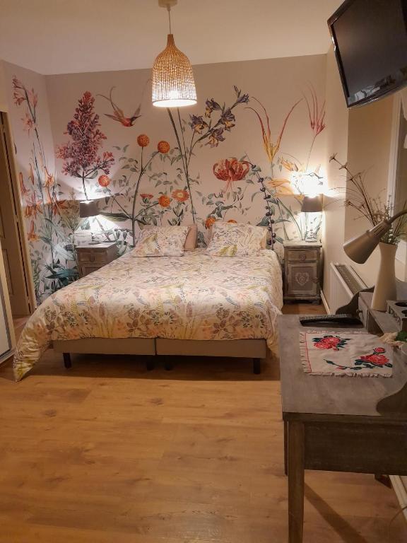 - une chambre avec un lit orné de fleurs sur le mur dans l'établissement Flopre, à Flocourt