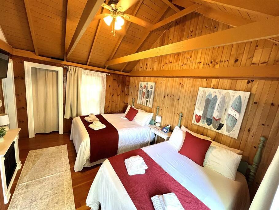 1 dormitorio con 2 camas en una habitación con paredes de madera en Cottage 11 - 1 Bed / 1 Bath w/ Private Courtyard, en Wolfeboro