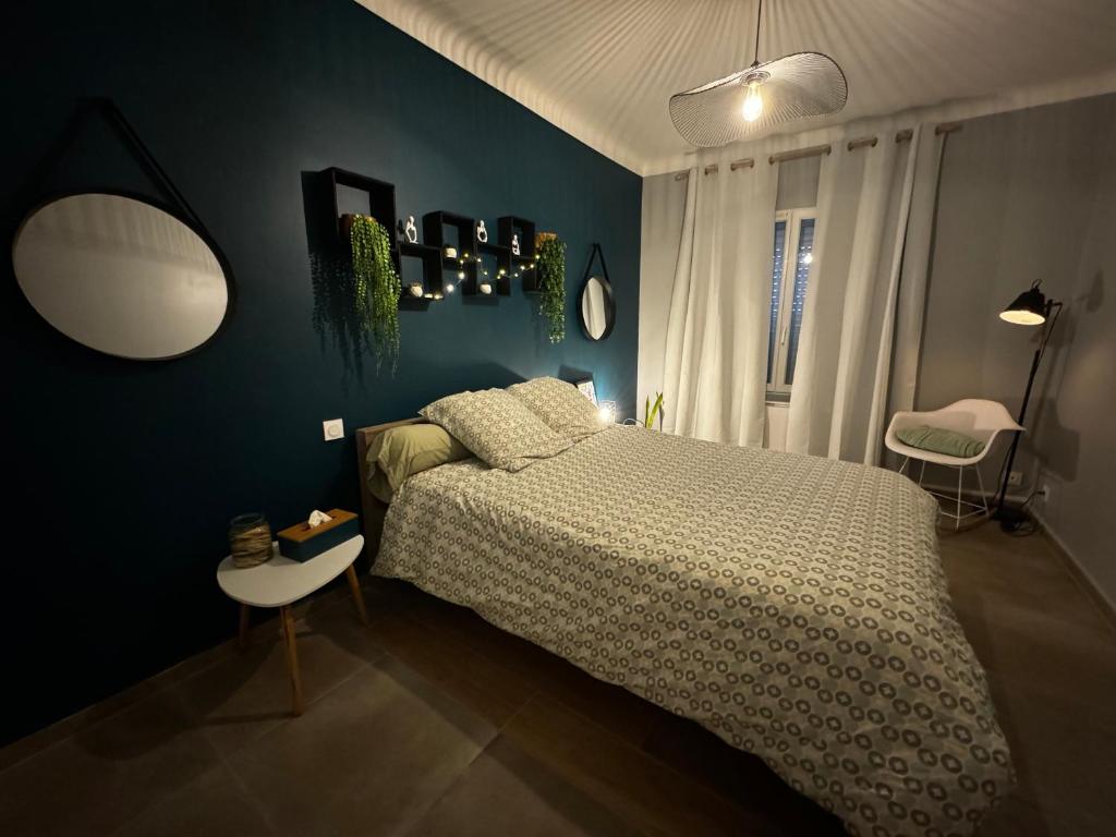 une chambre avec un lit et un mur bleu dans l'établissement Les Copains d'Abord, à Nîmes