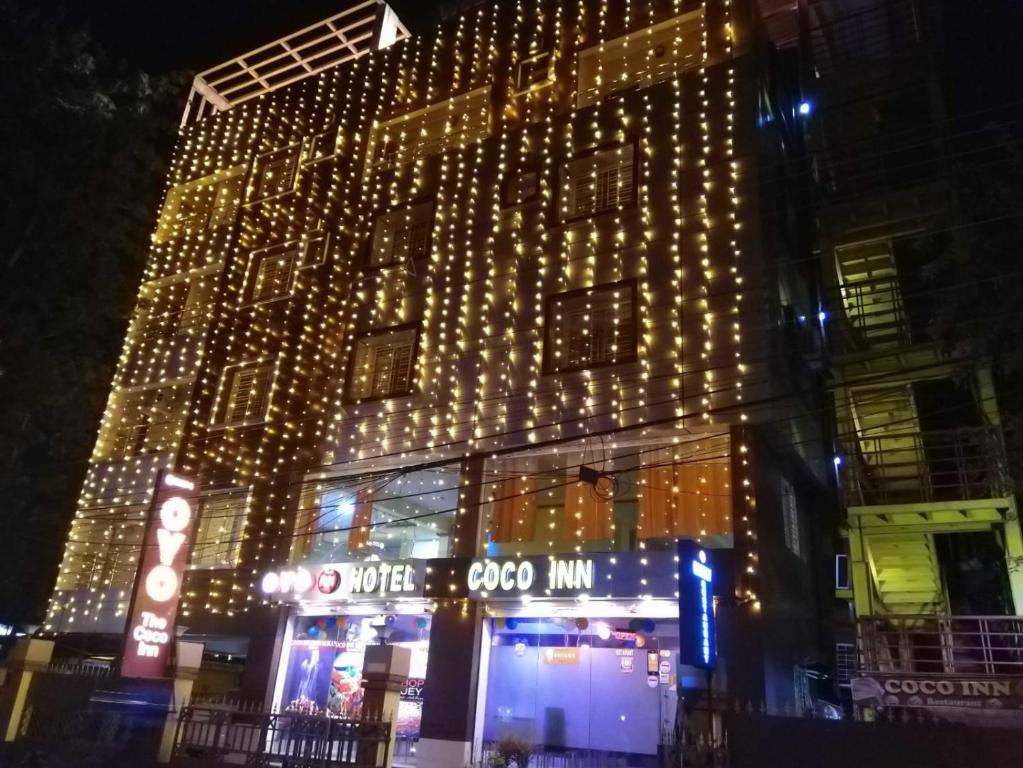 a lit up building with christmas lights on it at The Coco Inn Near South City Mall by Urban in Kolkata