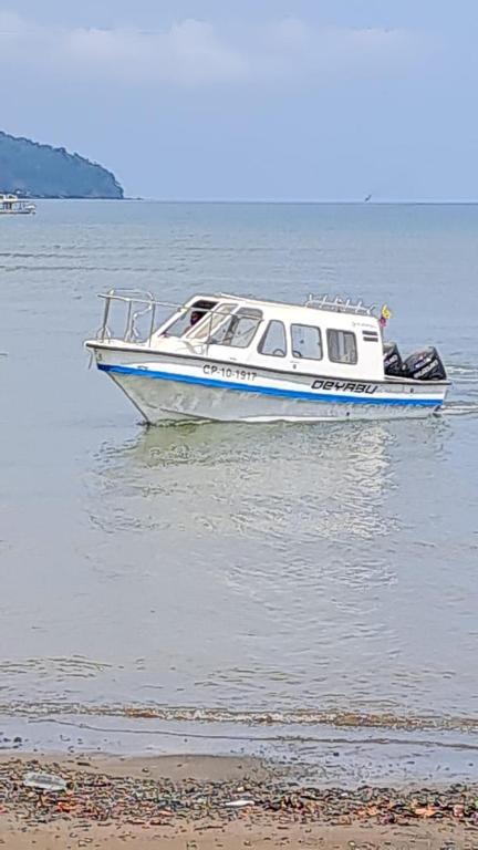 a small boat in the water near a beach at Alojamiento in Bahía Solano