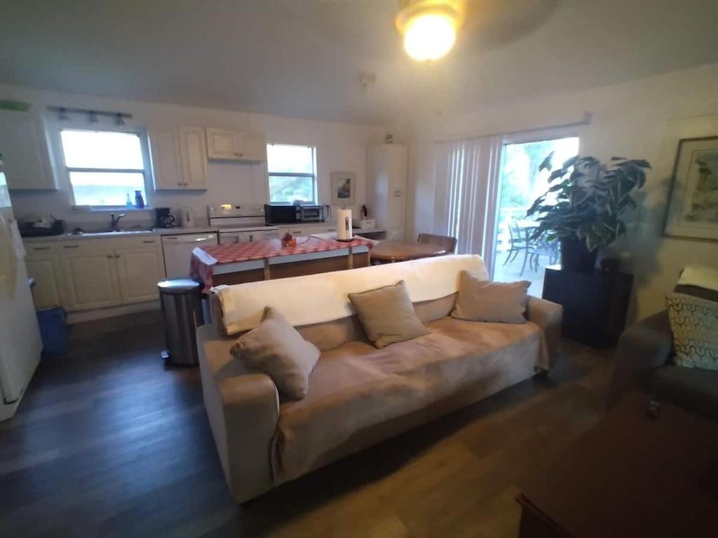 a living room with a couch and a kitchen at Lenny's Cooperative Hostel in Clearwater