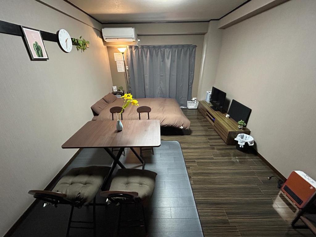 Cette petite chambre comprend un lit, une table et un bureau. dans l'établissement ＴＡＪＩＭＡ ＢＡＳＥ - Vacation STAY 16243, à Fukuoka