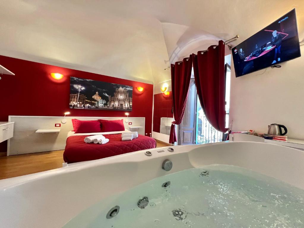 - une grande baignoire dans une chambre avec un lit dans l'établissement CANTU' SUITE, à Catane