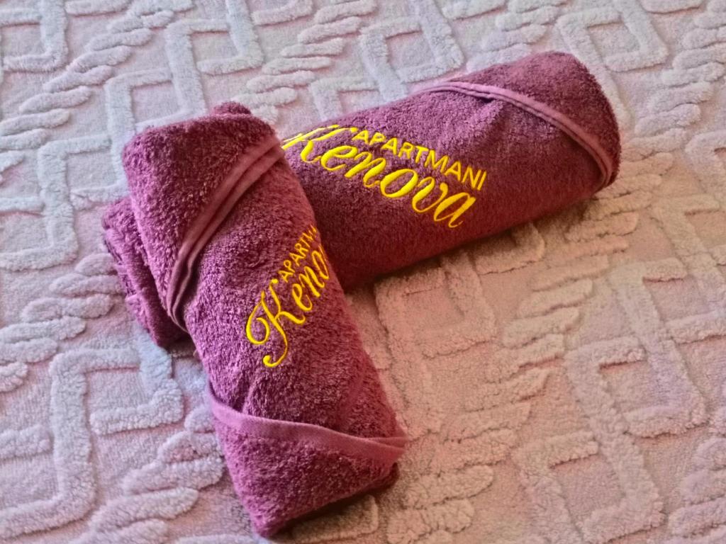 a pair of purple mitts sitting on a bed at Apartmani Kenova 4 in Herceg-Novi