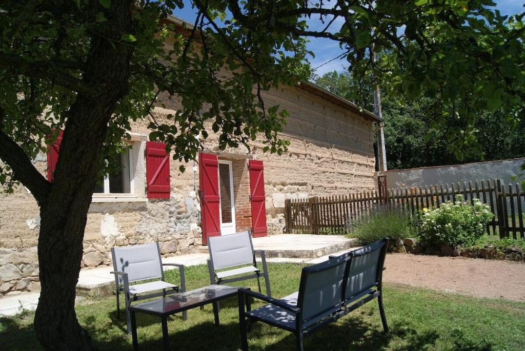 three chairs and a table in front of a house at Gîte de Magneux - Spa/Jacuzzi in Amions