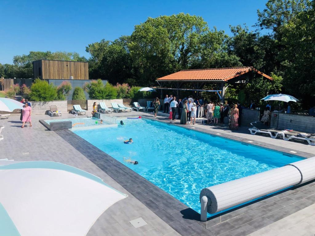 un groupe de personnes autour d'une piscine dans l'établissement Côté Océan Resort, à Angoulins-sur-Mer
