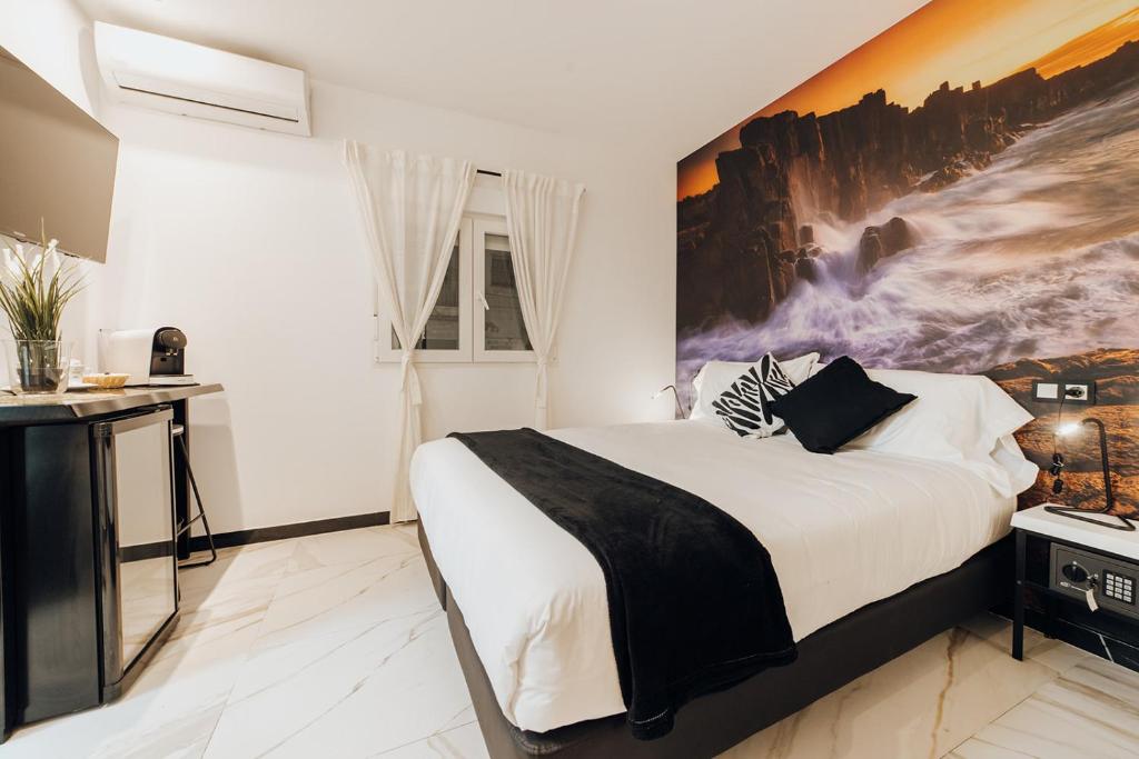 a bedroom with a bed with a large painting on the wall at HOSTAL LUXURY NIT I DIA in Altea