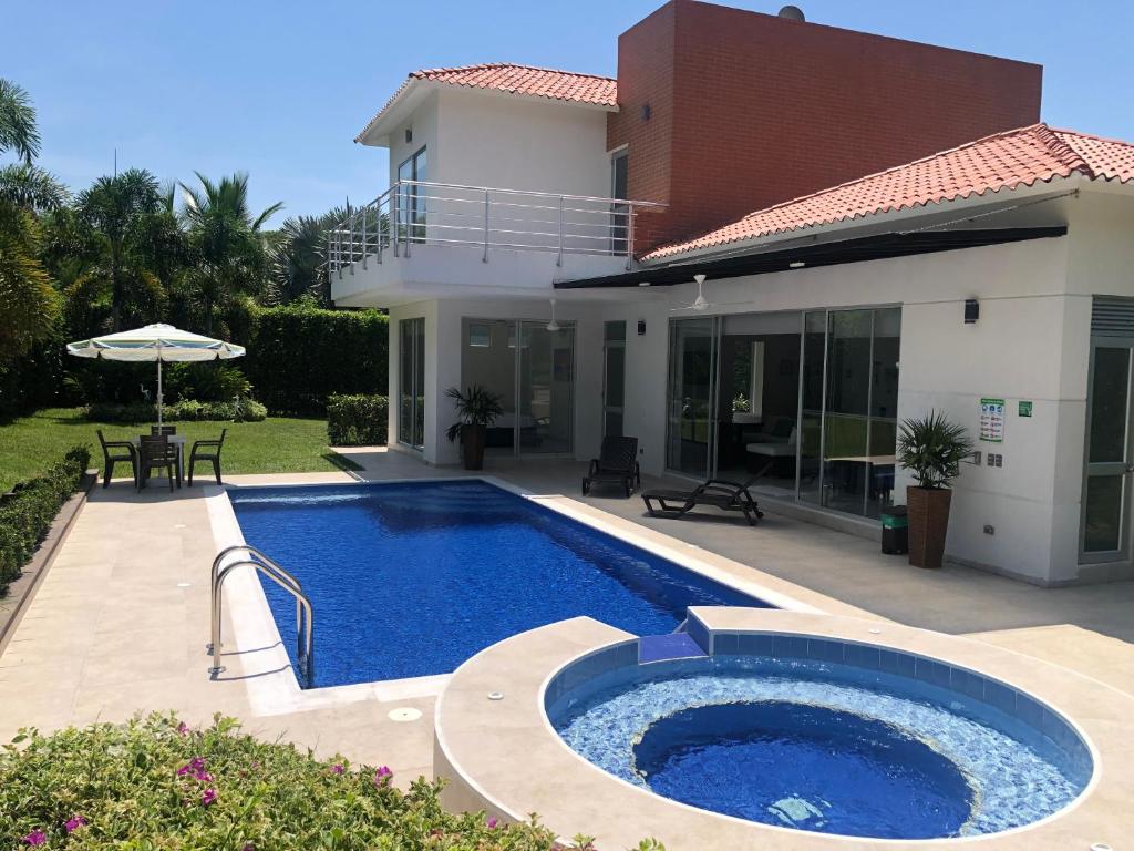 - une piscine en face d'une maison dans l'établissement Hermosa Casa de Descanso en Peñalisa, à Ricaurte
