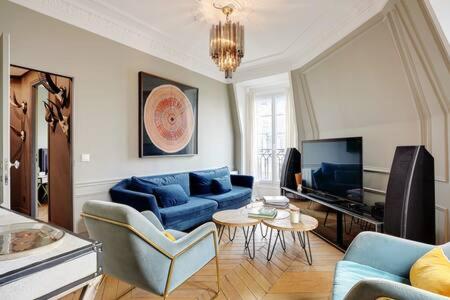 un salon avec un canapé bleu et une télévision dans l'établissement Appartement chic au cœur de Paris Montorgueil 2BDR, à Paris