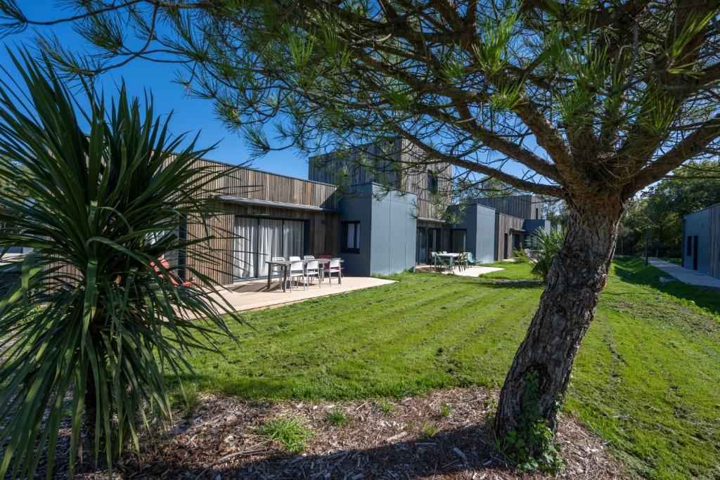 un palmier devant une maison dans l'établissement Côté Océan Resort, à Angoulins-sur-Mer