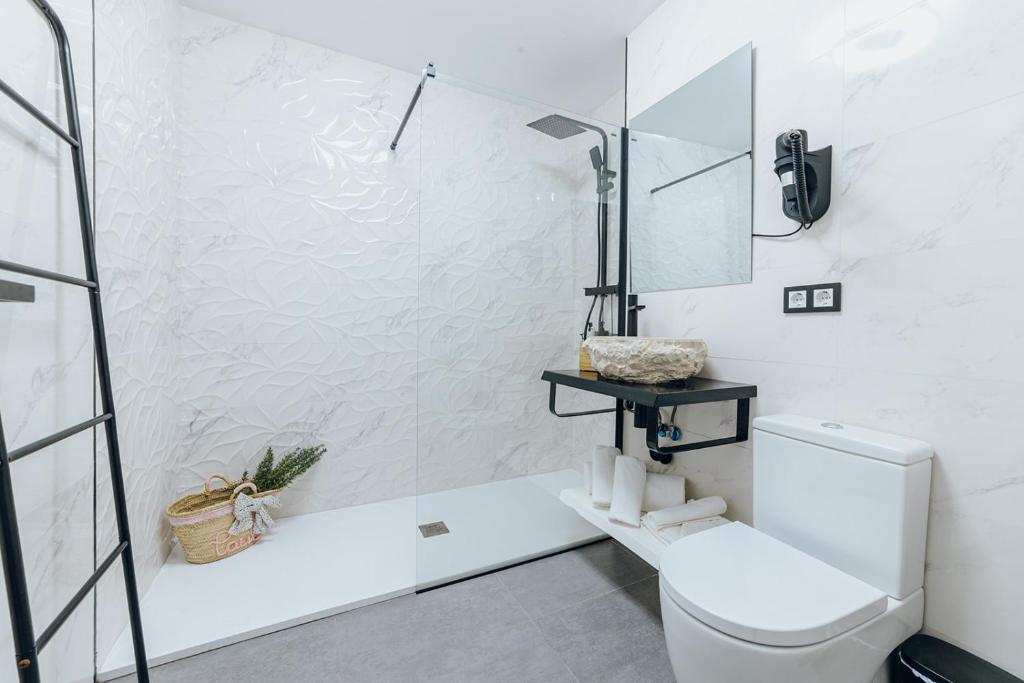 a white bathroom with a toilet and a glass shower at HOSTAL LUXURY NIT I DIA in Altea