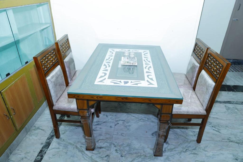 a dining room table with two chairs and a table and chairsuggest at JK Home Stay in Tirupati