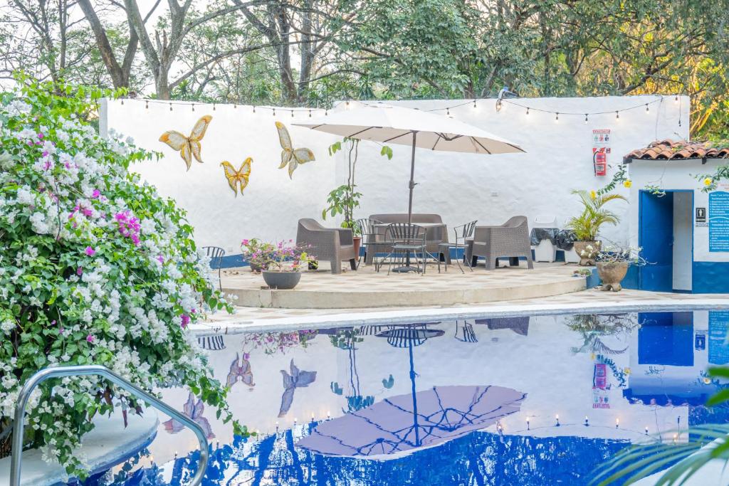 a swimming pool with a table and an umbrella at Hotel Aeropuerto in Alajuela