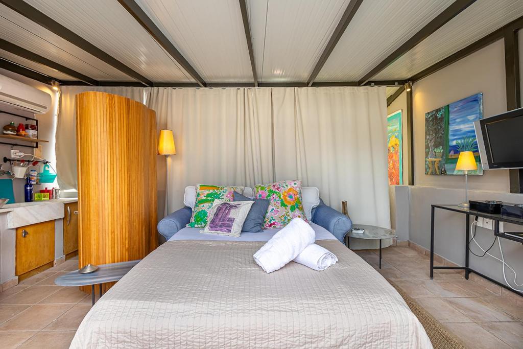 um quarto com uma cama com almofadas e uma televisão em Arthome Acropolis View em Atenas