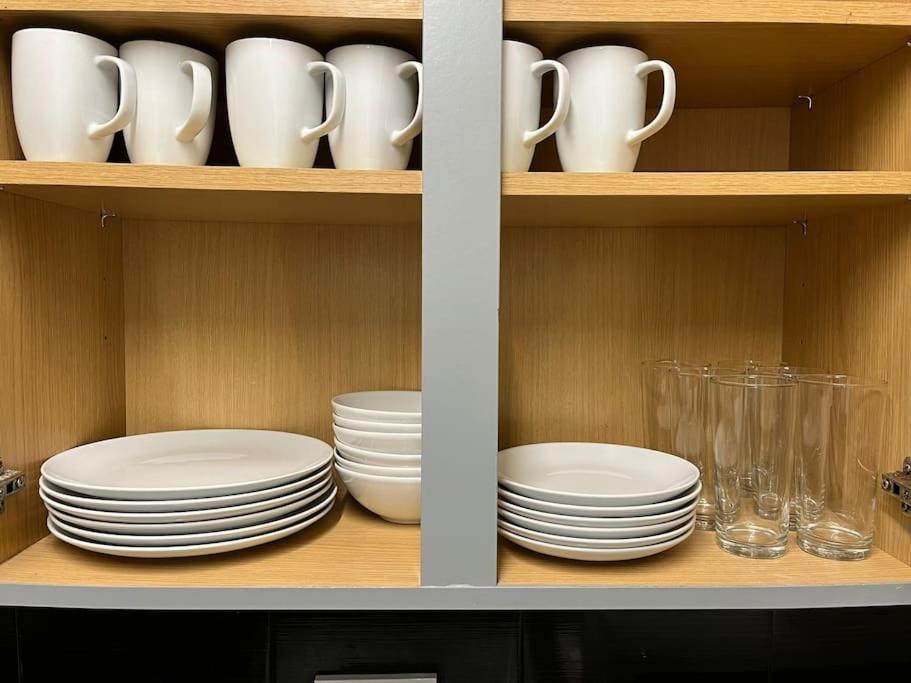 a shelf with plates and cups and dishes on it at Home from Home in Manchester