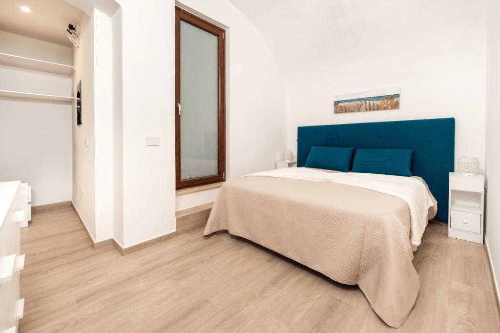 Schlafzimmer mit einem großen Bett mit blauem Kopfteil in der Unterkunft Le Balille - Po in Santeramo in Colle