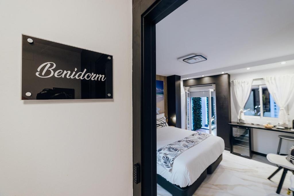 a bedroom with a bed and a sign on the wall at HOSTAL LUXURY NIT I DIA in Altea