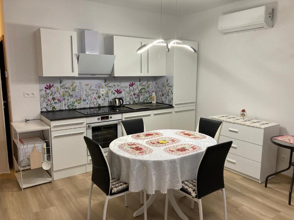 uma cozinha com uma mesa com uma toalha de mesa branca em Apartmán Alicante em Dunajská Streda