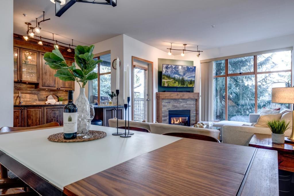 a kitchen and living room with a table and a fireplace at Central 2BR with Prime Amenities in Whistler