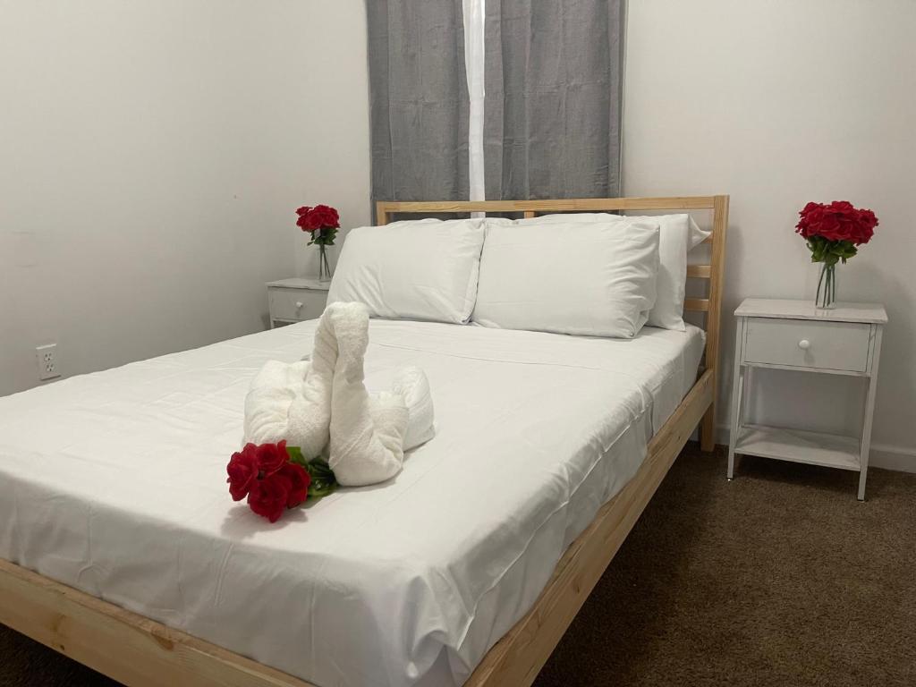 ein Bett mit zwei Handtüchern und Blumen drauf in der Unterkunft SUITE JESUS ROOM 3 in Paterson