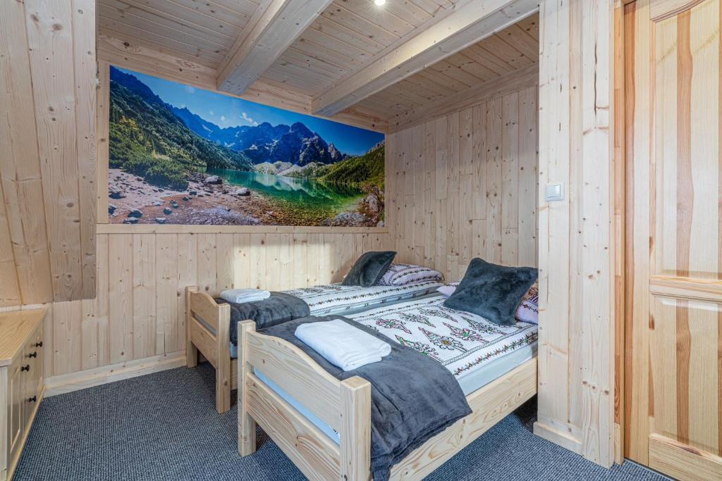 a bedroom with two beds in a wooden cabin at Domki na Wiyrchu in Biały Dunajec