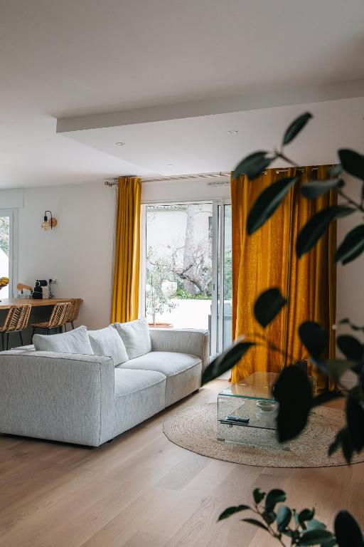 ein Wohnzimmer mit einem Sofa und einem großen Fenster in der Unterkunft Appartement Résidence Villeneuve in Villeneuve-lès-Avignon