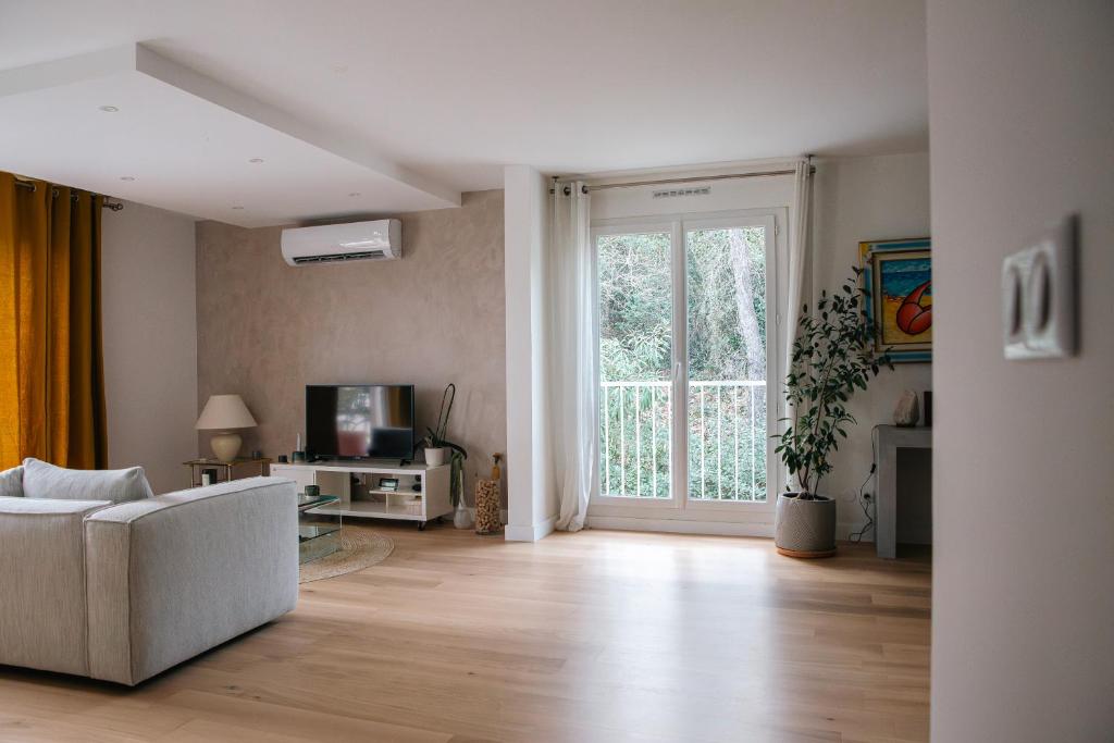 ein Wohnzimmer mit einem Sofa und einer Glasschiebetür in der Unterkunft Appartement Résidence Villeneuve in Villeneuve-lès-Avignon