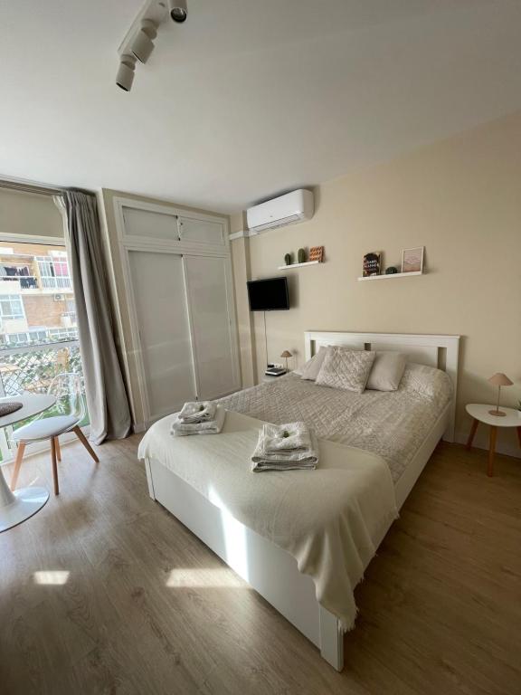 ein weißes Schlafzimmer mit einem Bett und einem Fenster in der Unterkunft Estudio Boutique en Benalmádena, Recepción 24 horas, Piscinas in Benalmádena