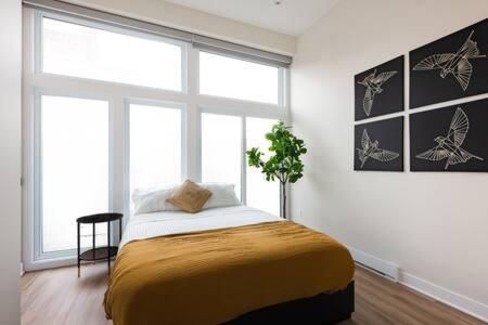 um quarto com uma cama e uma grande janela em Beautiful 2 BDR with Sofa Bed and Sky Light em Montreal