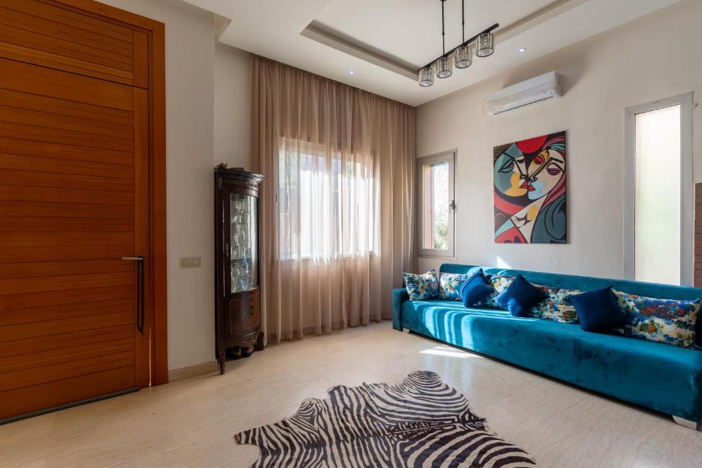 - un salon avec un canapé bleu et une porte dans l'établissement Villa Marrakech, à Marrakech