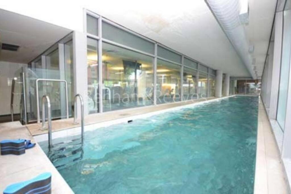 - une grande piscine d'eau bleue dans un bâtiment dans l'établissement 2Bed 2Bath -Pool, Balcony, Gym Lift, à Londres
