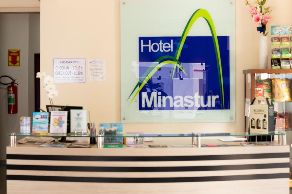 un comptoir dans un magasin avec un panneau sur le mur dans l'établissement Hotel Minastur, à Capitólio