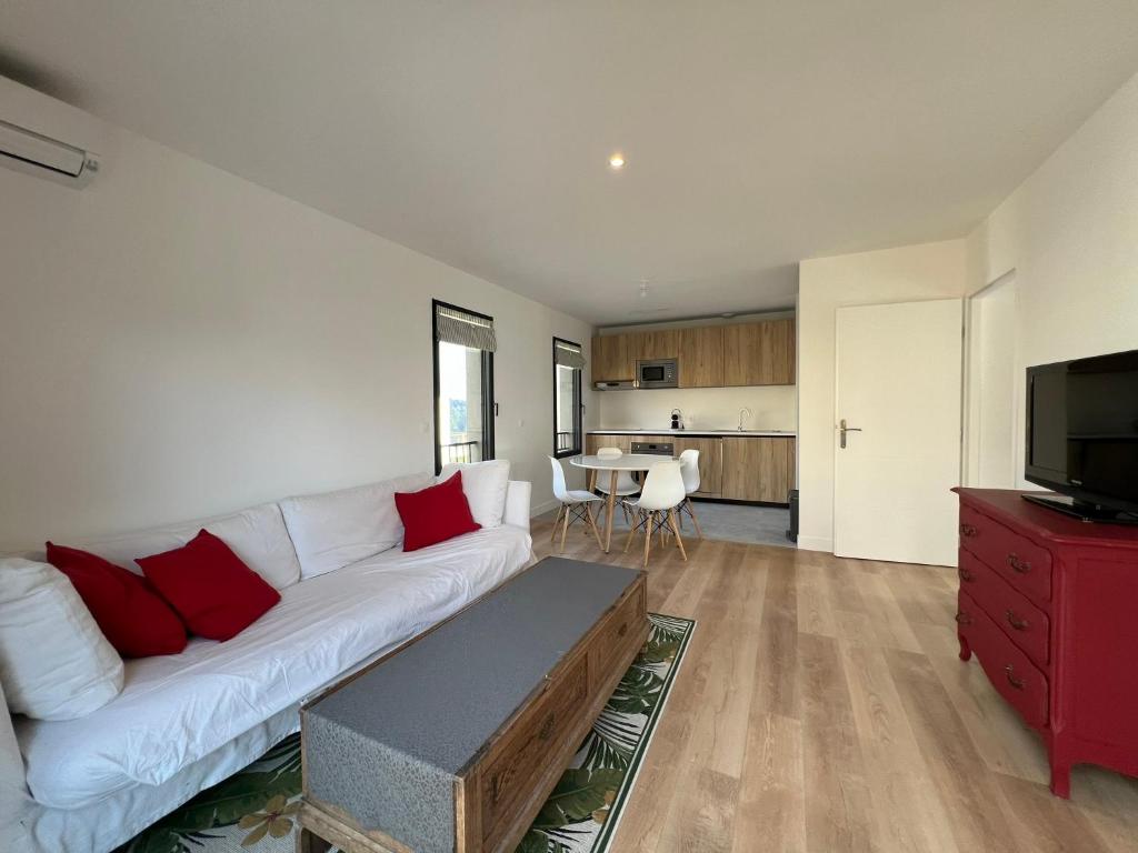 uma sala de estar com um sofá branco e um armário vermelho em Bel appartement proche de cannes em Vallauris