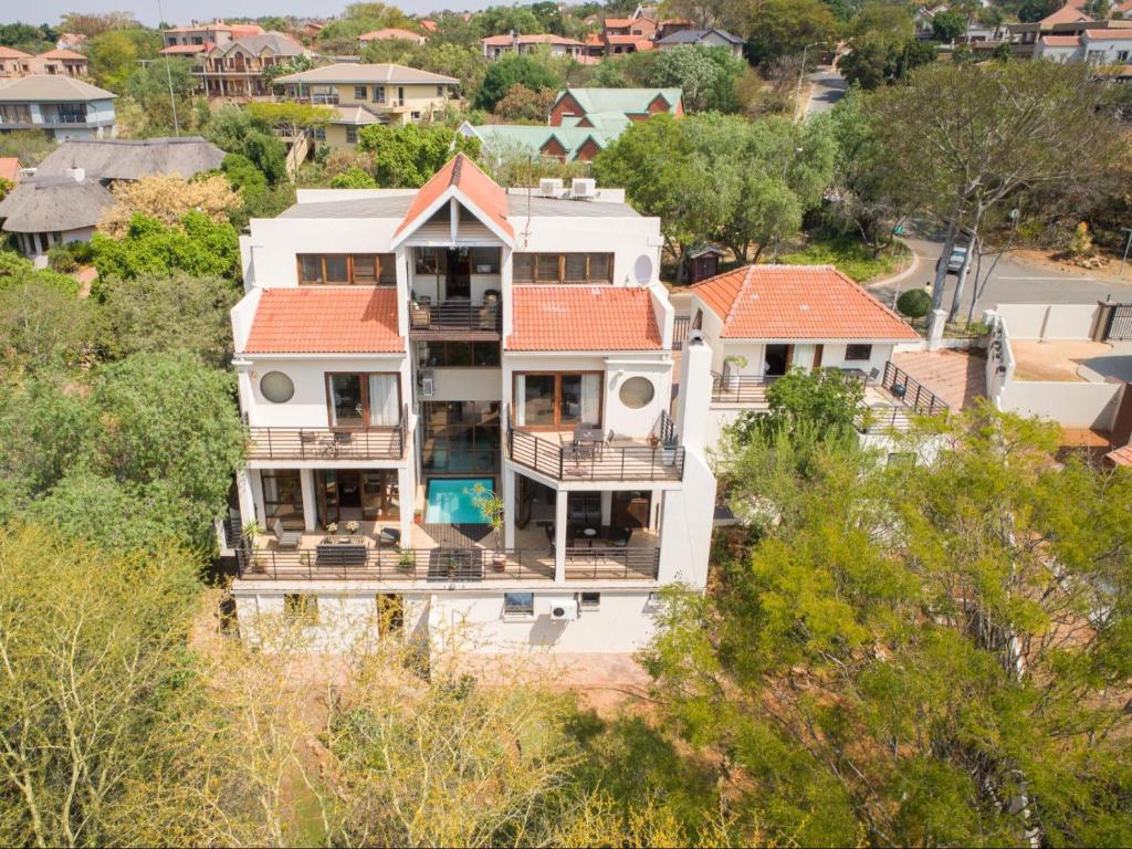 une vue aérienne sur une grande maison blanche avec un toit orange dans l'établissement Jopasso Guest House, à Pretoria