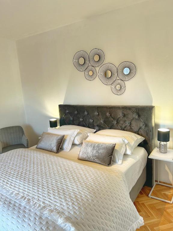 a bedroom with a large bed with two mirrors on the wall at Apartment Dario in Zadar