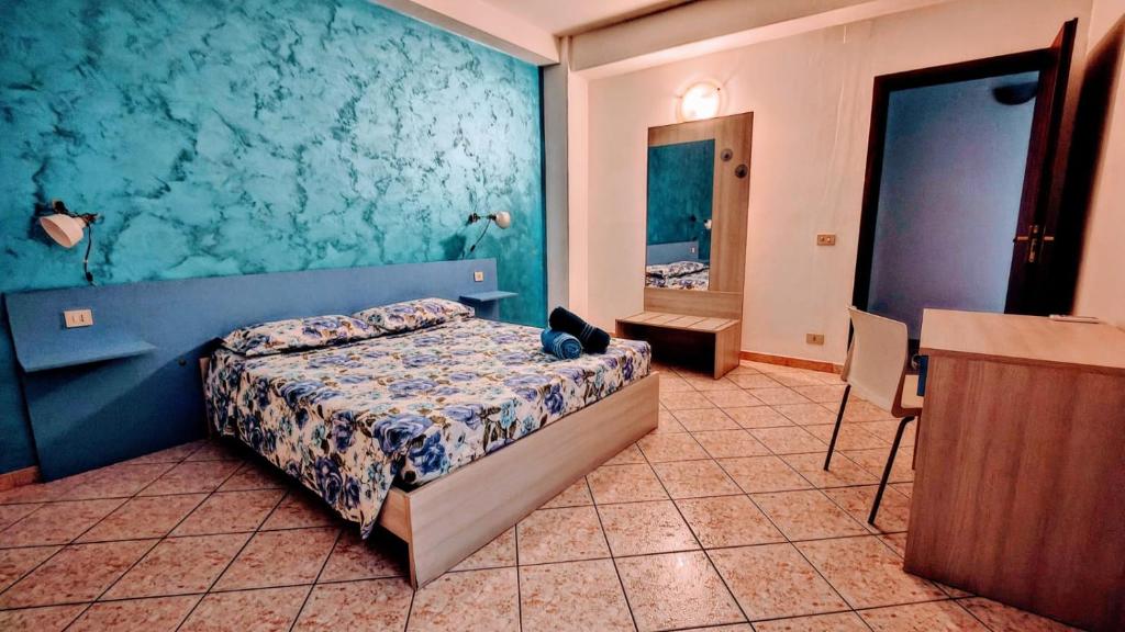 um quarto com uma cama com uma parede azul em La Casa Del Viale em Solarino