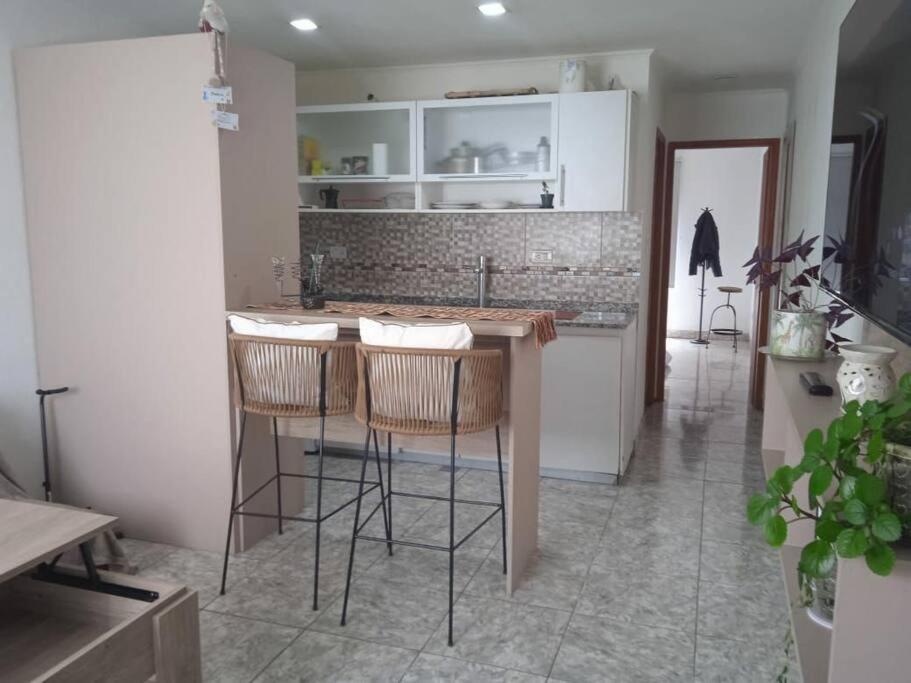 a kitchen with a counter and stools in a room at Departamento equipado Río Grande in Río Grande