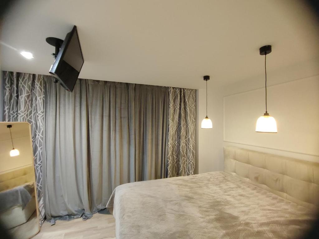 a bedroom with a bed and a flat screen tv at DWUPOKOJOWY APARTAMENT 51 m2 in Łódź