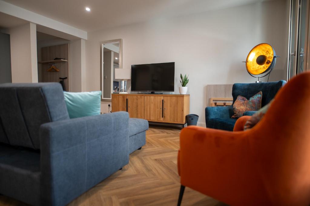 a living room with two chairs and a television at Kilkenny Suites in Kilkenny