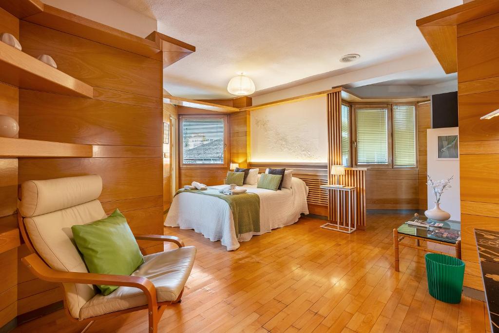 een slaapkamer met een bed en een stoel bij Apartamento Alminar in Granada
