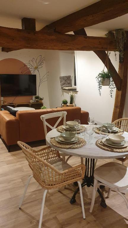 una mesa y sillas en una sala de estar con sofá en Petite bulle de Saint Remacle, en Stavelot