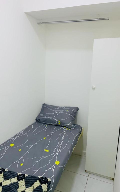a bed in a room with a white wall at Bright Rooms in Dubai