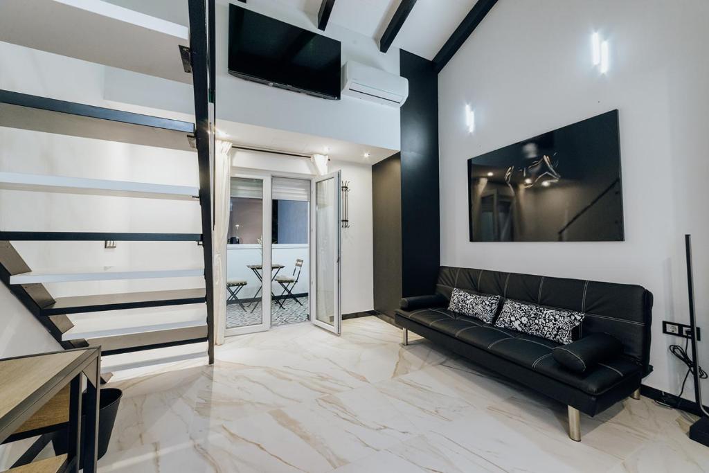 a living room with a black couch and a tv at HOSTAL LUXURY NIT I DIA in Altea