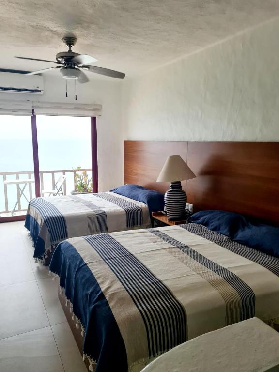 a bedroom with two beds and a ceiling fan at Hotel los tules 12-501 in Puerto Vallarta