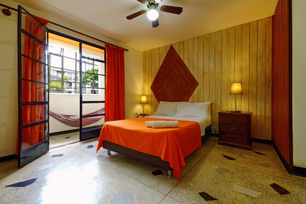1 dormitorio con 1 cama con manta naranja en Ding-Dong Hostel, en Cali